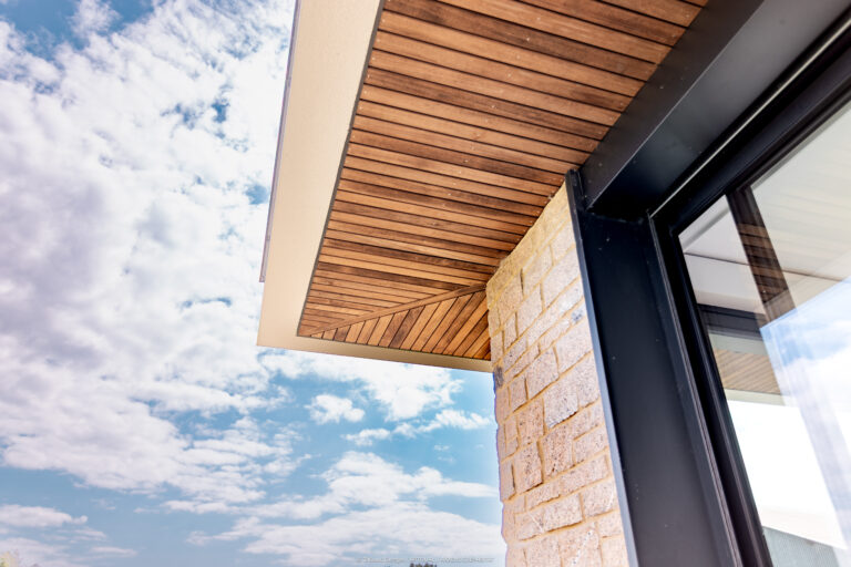 Détail d’architecture : bois, pierre et aluminium sur maison contemporaine à Locoal-Mendon