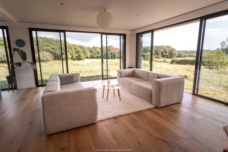 Salon lumineux avec grandes baies vitrées et vue sur la campagne — maison contemporaine Locoal-Mendon